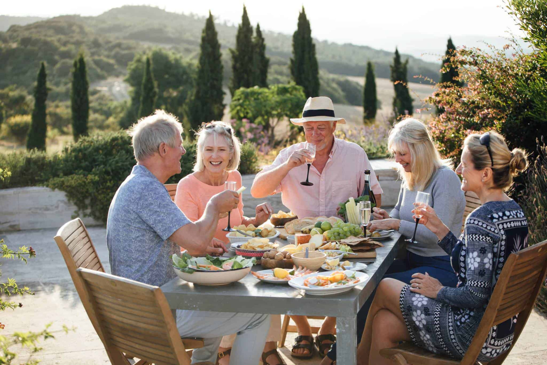 A group of retirees sharing a meal outdoors in the Italian countryside