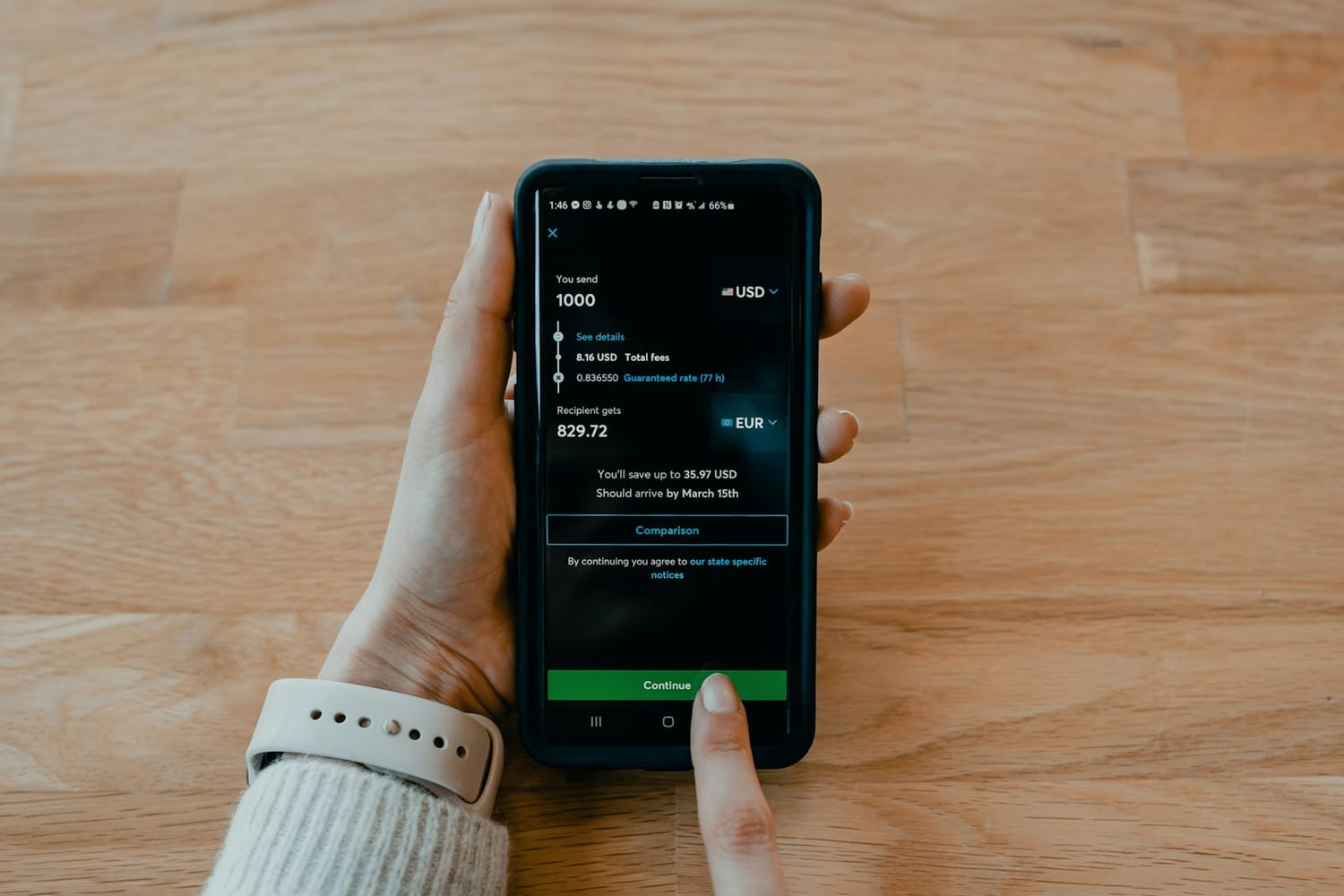 Hands holding a smartphone with a banking app converting dollars and euros