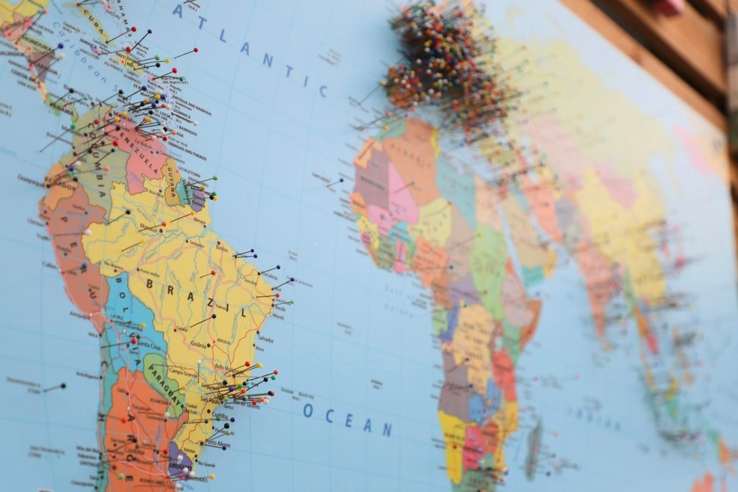 A world map with coloured pins marking places across the Americas and Africa