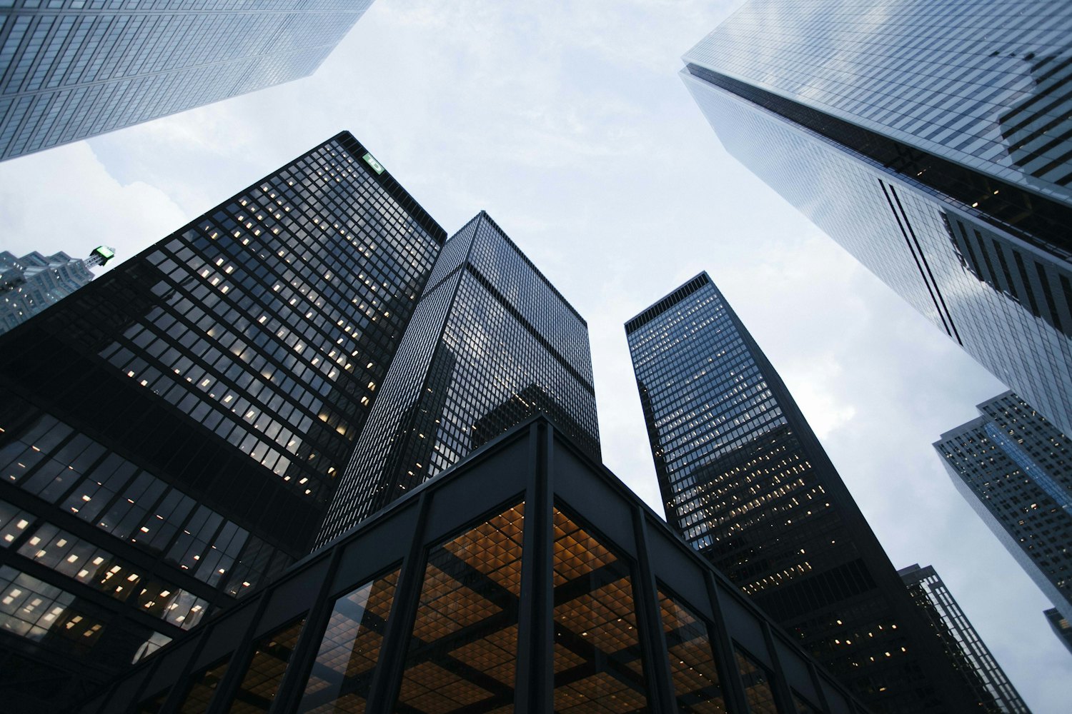 Glass office towers seen from street level against a pale sky