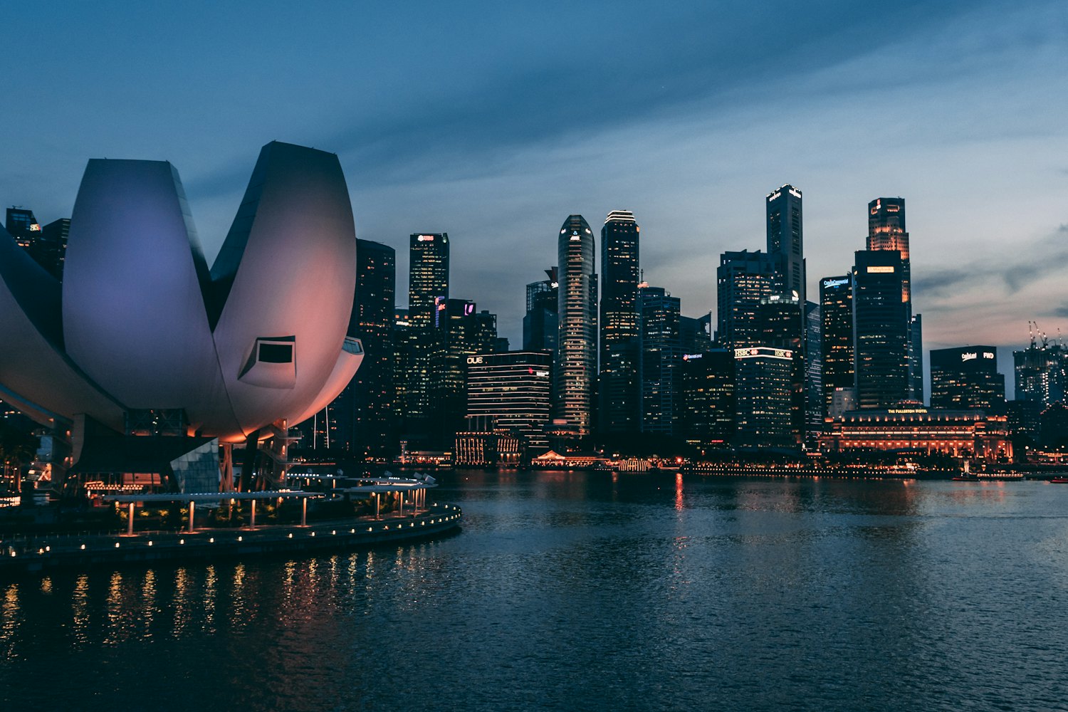 Il distretto finanziario di Singapore e l'ArtScience Museum oltre Marina Bay al crepuscolo