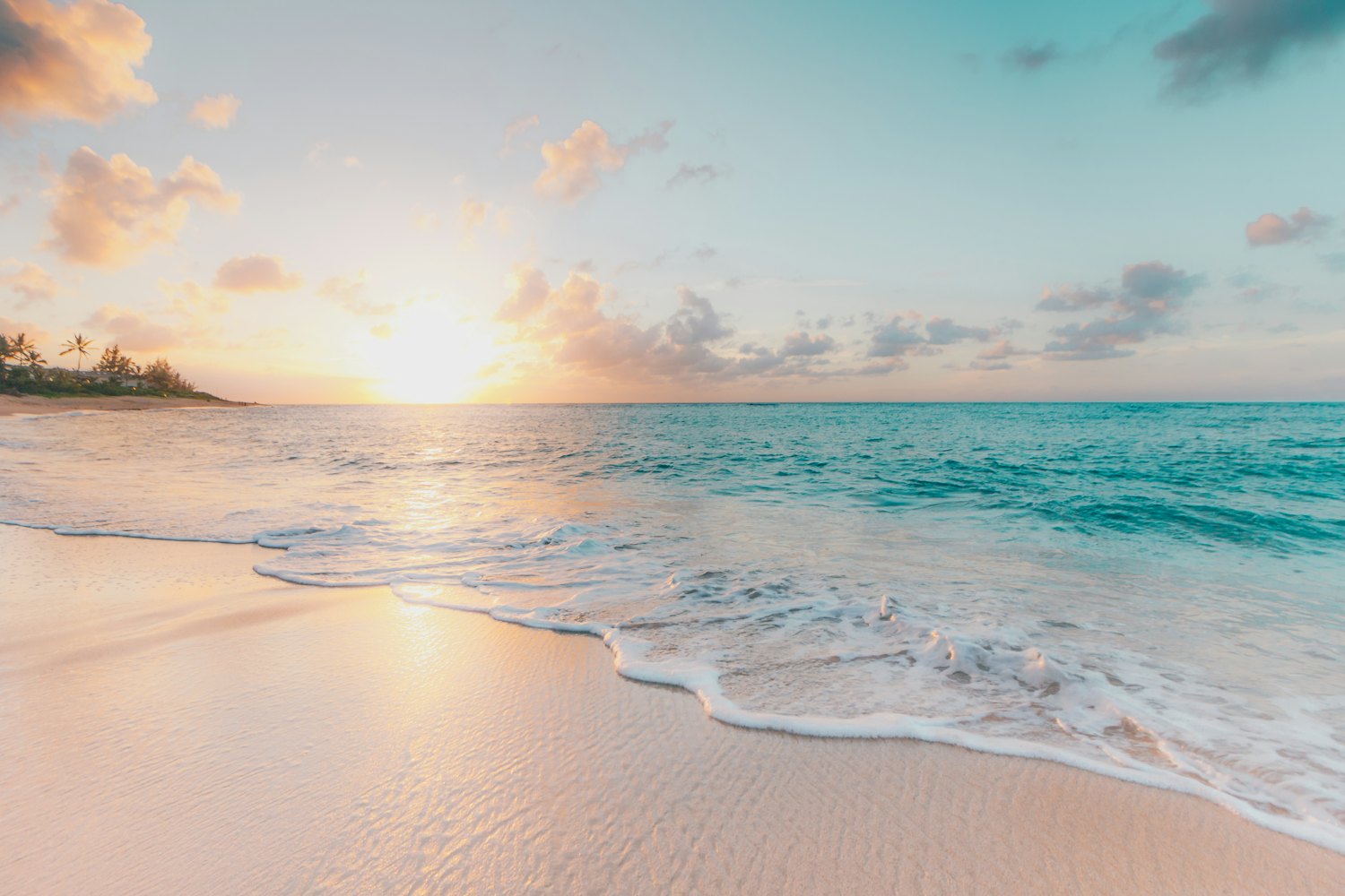 Caribbean beach at sunrise with gentle waves on the sand