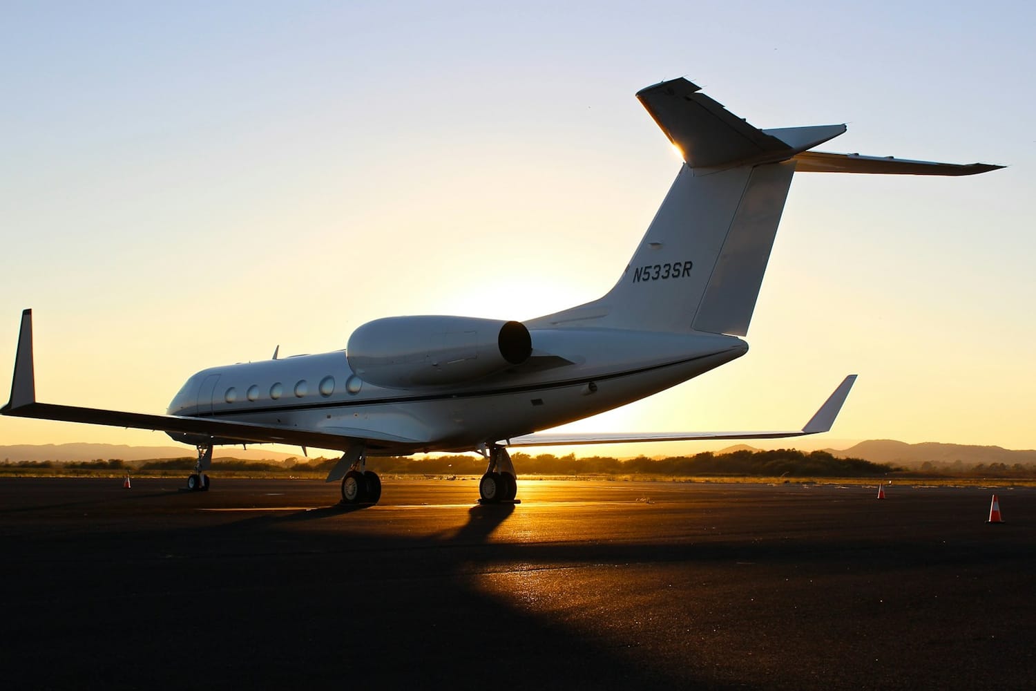 A private jet on the runway at sunset