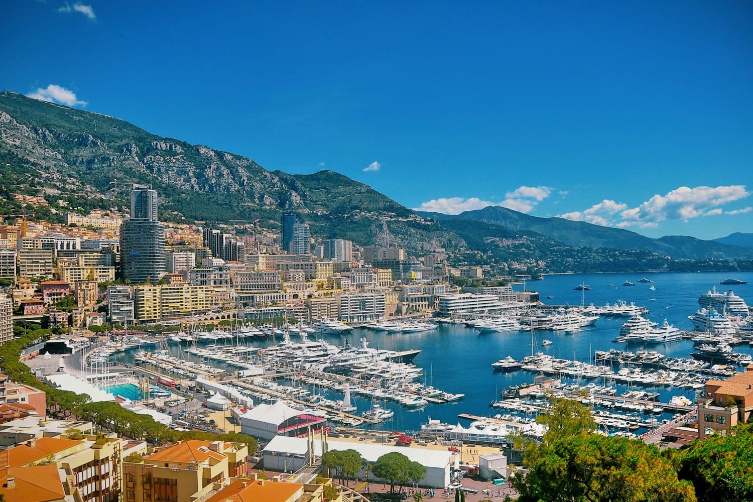Monaco's harbour full of yachts below apartment towers and mountains