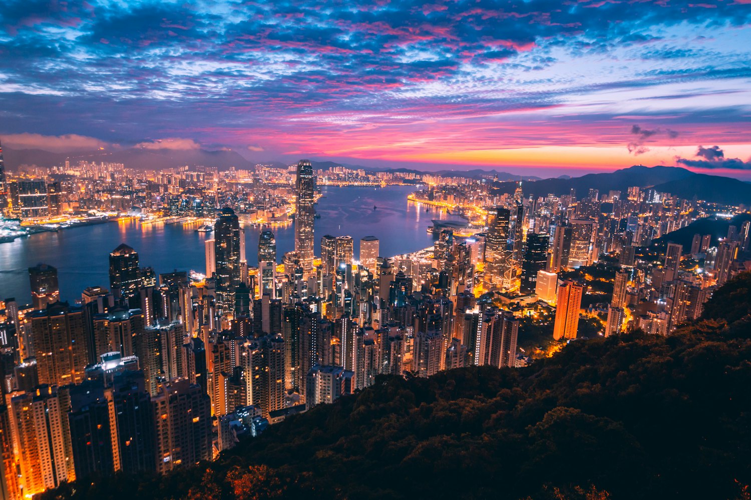 Hongkong und Victoria Harbour in der Abenddämmerung, vom Peak aus gesehen