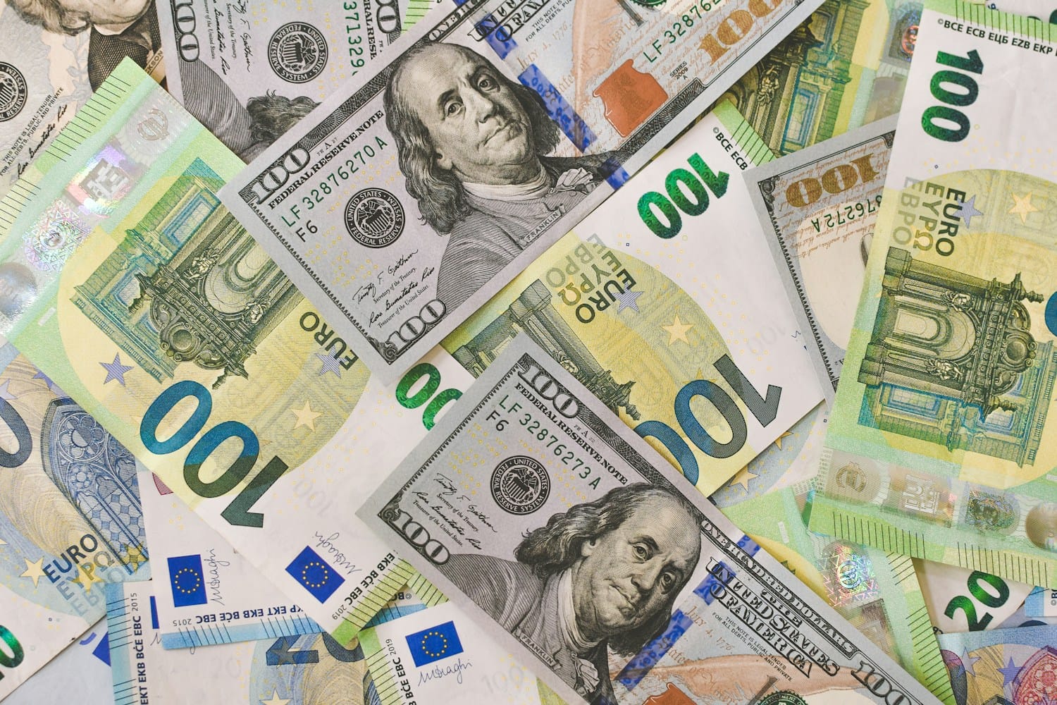 U.S. dollar and euro banknotes spread on a table